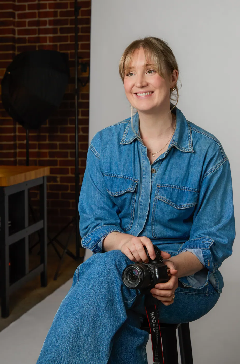 Katie Graham holding a camera in a studio